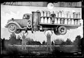 Fotomontage där män lyfter mjölkbil