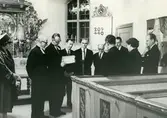 Inventariegenomgång i Kållereds kyrka i samband med Biskopsvisitationen år 1966. Från vänster ses Marta Nilsson (från syföreningen), kyrkoherde Lennart Levén, biskop Bo Giertz (som studerar inventarieboken), kyrkvaktmästare Arvid Persson, kyrkvaktmästare Karl Olofsson, kyrkorådet Alvar Andersson, komminister Gustaf Lindman (ryggen mot kameran), ordförande i kyrkorådet Eivind Kullbring, kyrkorådet Margit Johansson samt kantor Bengt Forsberg.