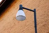 Hög gårdslampa mot husfasaden. Gårdssidan av husen som har adresserna Bergmansgatan 4, 6, 8 och 10 i Mölndals Centrum. Fotografi taget den 26 februari 2018. Byggnadsdokumentation inför rivning.