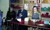 Julförsäljning av hantverk i pensionärernas hobbylokal på Våmmedalsvägen år 1977. Från vänster: 1. Okänd kvinna. 2. Einar. 3. Ester Karlsson (1907 - 2001) som sitter och fikar.