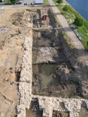 Den östra kurtinen (sjömuren) frilagd i samband med en arkeologisk undersökning av delar av Jönköpings slott i centrala Jönköping. Fullmuren slutar i höjd med grävmaskinen. I den främre delen av bilden syns grunden till Vattenkonsten (ett pumptorn) samt delar av en verkstadsbyggnads stensyll.