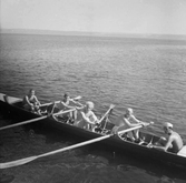 En stor kanot med fyra roddare, troligen på Vättern i Jönköping. I aktern sitter en så kallad cox (taktropare) som höll takten och styrde.