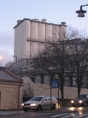 Rivningen av Soabs silo i Mölndals Kvarnby. Vy från Gamla Torget. I förgrunden ses trafik på Kvarnbygatan. Fotografi taget den 4 december 2008. Byggnadsdokumentation under rivning.