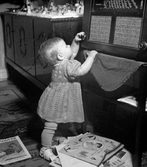 En nyfiken liten flicka skruvar på radioapparatens knapp.