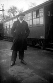 Fotograf Gustav Andersson står på perrongen vid en tågvagn för 3:e klass.