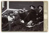 Gruppbild utanför Sylstugan vid invigningen 1897. Män och kvinnor sittande i slänt utanför raststuga.