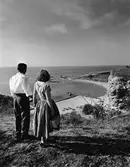 Man och kvinna tittar ut över badstranden vid Snäckgärdsbaden, Visby