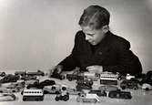 Pojke med en samling leksaksbilar. År 1947