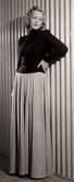 Franska avdelningen vid Nordiska Kompaniet 1939. Kvinnlig modell poserar i jumper med polokrage och lång vid kjol.