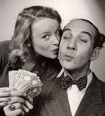 Reklamannons för Nordiska Kompaniets generalrea 1944. En man i kostym och fluga och en ung kvinna sedda framifrån, de står leende och håller en bunt sedlar tillsammans, hon kysser honom på kinden.