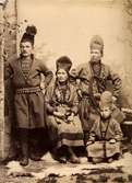 Gruppbild med fyra personer iklädda samiska folkdräkter. Studiofotografi 1912.