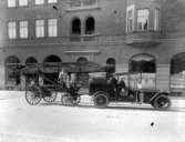 Brandkåren. Tre personer från brandkåren med bil och stegvagn på Nyatan. Bilen står framför Centralpalatset. Stegvagnen finns kvar i Trelleborg nu år 2004.