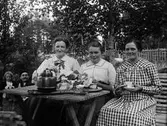 Svägerskorna Nora, Maja och Berta Ärnström vid kaffebordet, Hållnäs socken, Uppland