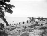 Turister på berghäll vid stranden, Furuvik, Gästrikland augusti 1910