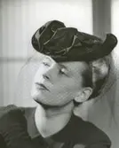 Porträtt av kvinna i hatt med flor.