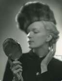 Fb, Porträtt av kvinna i pälshatt med spegel i handen.