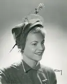 Porträtt av kvinna i guldbrun velourhatt med flor och fantasie, av Jacques Fath