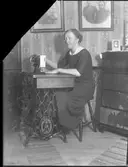 Hemsömnad, symaskin, kvinnoporträtt