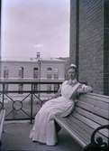 Sjuksköterska sitter utomhus på en bänk på en balkong