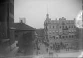 Kungstorget. Lysekil, med en procession med musik, hästskjutsar och ridande