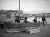 Tre barn i en båt upplagd på en kaj