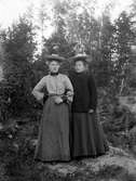 Två kvinnor i skogsbacke