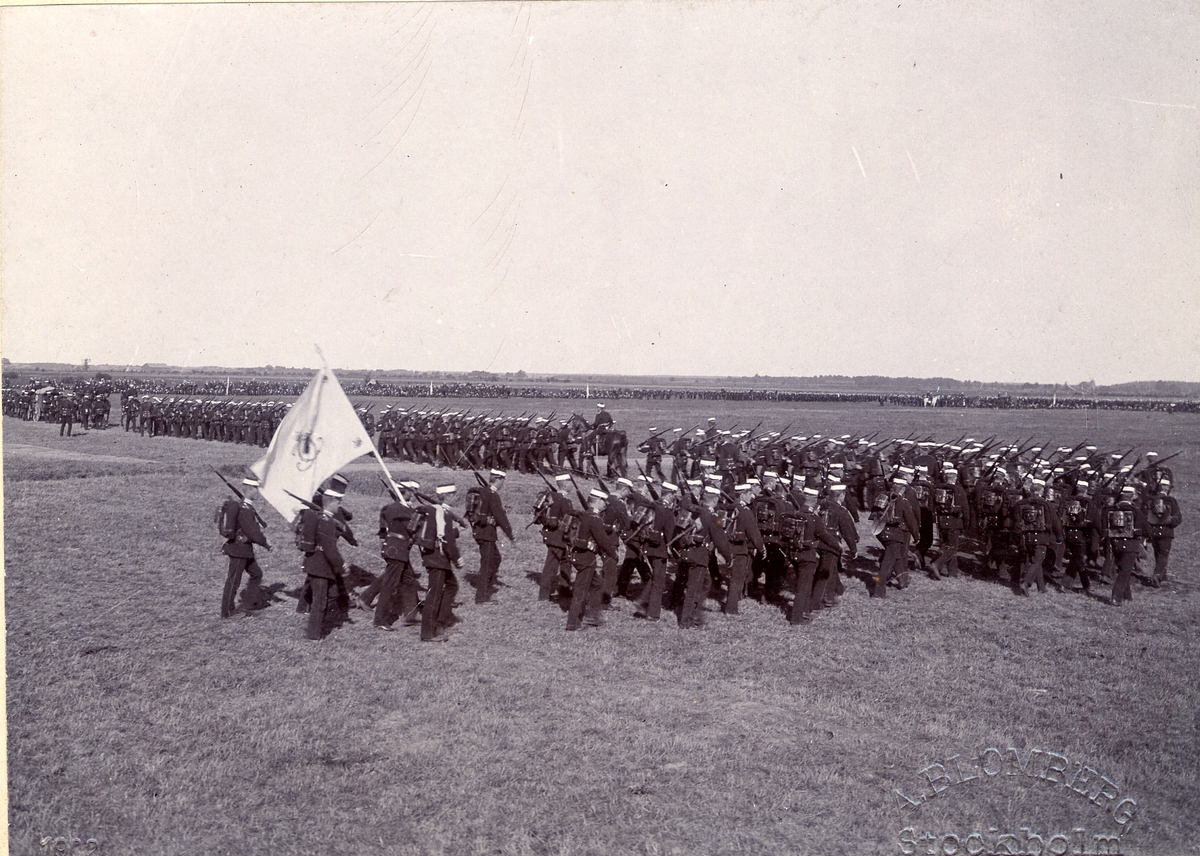 Anton Ambrosius Blomberg, Göta livgarde I 2 ute på marsch 1902. Soldaterna bär uniform m/1886 och är utrustade med full packning. Längst bak går soldat med regementets fana.