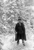 Gustav Andersson står i snöig skog.