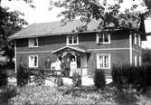 Ett släkt-och familjeporträtt framför huset, med snickarglädje på verandan.