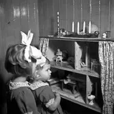 Två barn vid ett dockskåp.