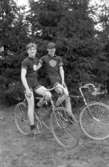 Två unga män med cyklar tränar för Jönköpings cykelklubb, på deras tröjor står JCK.