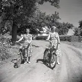 Märta Blom och Ellen Andersson med cyklar. Bilden är tagen i närheten av kyrkans sommarhem i Edeskvarna.