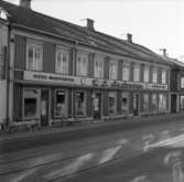 Affärer i huset på Klostergatan 18 i Jönköping med byggnadsår 1876. Till vänster syns fäste för spårvagsnledningar.