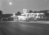 BP bensinstation på Grännavägen 18, Huskvarna. Den startades på 1930-talet. Detta foto är taget år 1956 och dess ägare och föreståndare var då Gustav Thörnblad. Längre norrut skymtar Huskvarna Borstfabrik och Junex konfektionsindustri.