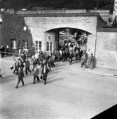 Anställda på väg ut genom fabriksporten till Husqvarna Vapenfabriks AB som bildades 1867 och var en efterföljare till Jönköpings Gevärsfaktori.