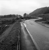 Det var inte länge sedan landets viktigaste väg var belagd med gatsten. Detta är den gamla Riksettan vid Huskvarnas norra utfart. Ombyggnadsarbeten pågår i höjd med Brunstorp på 1960-talet.