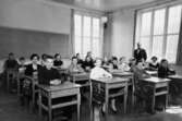 Åk. 5, Krokslättsskolan 1953. Lärare Per Hasselgren med elever. Pojkar och flickor som sitter i skolbänkar.