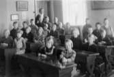 Gruppfoto av flickor och pojkar i klassrum i Kärra skola, samt lärare Emma Aronsson.