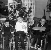 Tre barn framför en julgran på Stretereds skolhem, cirka 1950.