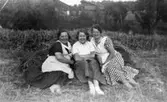 Fru Lindström med dotter och Helga sitter i höet. Hallen, Kållered 1929-1950-tal.