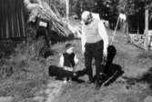 Arvid Svensson (f. 1903), murare och spelman, med barnbarnet Anders Garthman (f. 1968). Båda bär på var sitt fiolfodral. Arvid är morfar till Anders. Långö, Hällesåker 1970-tal.