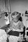 Bosgårdens barnträdgård 1938-1945. En flicka som leker med en docka.
