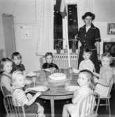 Bosgårdens barnträdgård 1938-1945. Flera barn som sitter runt ett bord med en tårta på.