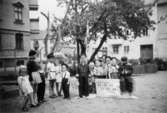 Troligtvis daghem i Guldheden, Göteborg 1945-. Flera barn som står på en lekplats.