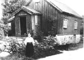 Annestorp i Lindome på 1920-talet. Maria utanför sin stuga. (anteckning av H.B). Maria var rörelsehindrad och arbetade på fabriken. Hon var född 1846.