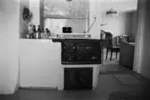 Roten L 13 i Mölndals Kvarnby. Lägenhetsinteriör från rotebostad. Kök med gammal vedspis.