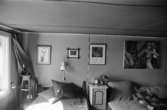 Bostadshus Roten M 10, okänt årtal. Interiörbild av ett rum med bl.a en soffa och en säng.