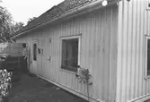Exteriörbild av bostadshus med förstuga och uthus på Roten M 32 i Mölndals Kvarnby, 1972.