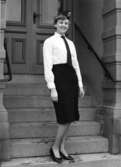 Vinteruniform för kvinnlig postiljon. Foton 4/2 1960.  Modell är Maud Bergström, bankavdelningen.  Utan kavaj. Med vit skjorta och högklackade skor.