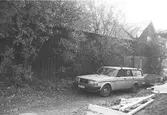 Ladugård och en Volvo vid Toltorpsgatan 9, mitt emot kiosk. Bilden är tagen under 1990-talet.